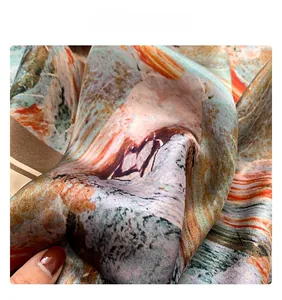 Close-up of silk scarf fabric showing oil painting print texture and soft drape