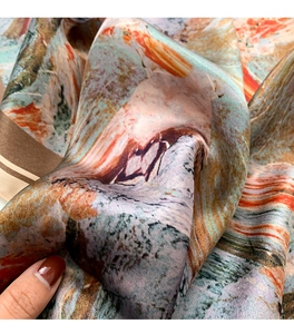 Detail showing soft texture and artistic oil painting pattern on silk scarf fabric
