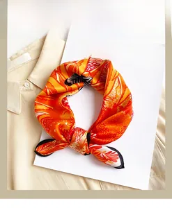 Detail view of a bright orange silk scarf with zebra and leaf prints on a shirt