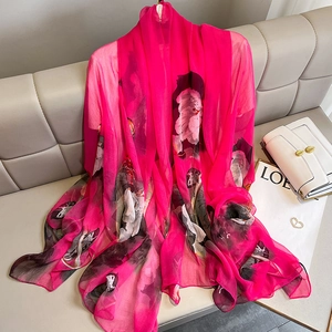 Elegant rose red floral chiffon scarf draped on a leather sofa for a stylish summer look