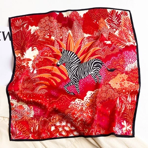 Detailed close-up of jungle zebra print red silk scarf with delicate hand-stitched black edges