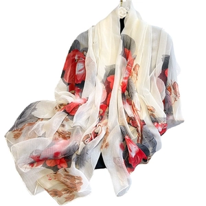 Elegant floral print silk scarf in cream white with vibrant red blossoms and tan leaves
