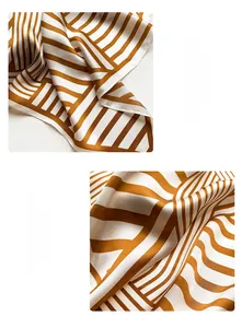 Detailed macro view of the professional machine-stitched edge on a striped silk scarf
