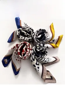 Macro shot of silk leopard print scarves in four colors with smooth satin texture