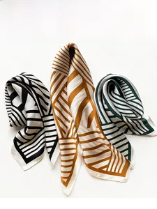 Detailed view of striped silk neckerchiefs in black, gold, and green geometric patterns