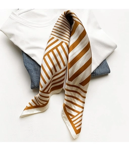 Detail of elegant striped satin silk scarf in brown and cream on casual outfit