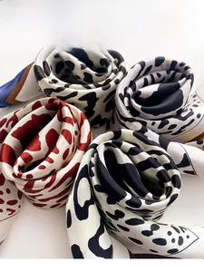 Detail of silk-like neck scarves featuring stylish animal prints in black, white, and red