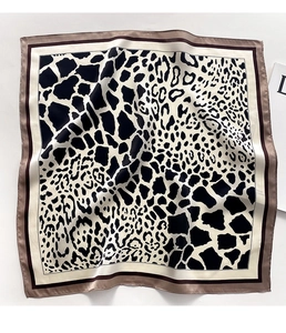 Detailed close-up of a leopard and giraffe print silk neck scarf with double borders