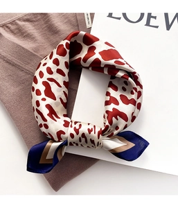 Macro shot of silk satin scarf featuring leopard patterns and blue color-block borders