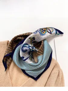 Detailed view of silk scarf with navy paisley and geometric patterns on knit background