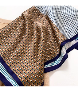 Close-up of elegant mulberry silk square scarf featuring geometric patterns and smooth texture