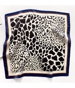 Detail of soft leopard and giraffe print silk scarf with blue and brown contrast borders