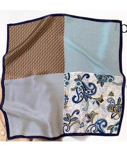 Detail of silk square scarf featuring paisley patterns and geometric textured patchwork