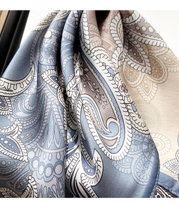 Gros plan d'un foulard en soie avec motifs paisley et texture satinée lisse