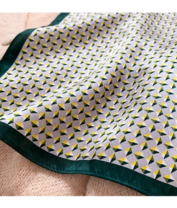 Detailed view of silk scarf with geometric triangle patterns on knitted fabric