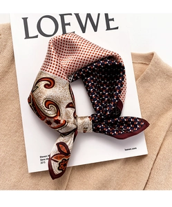 Detail of silk scarf with paisley patterns and navy plaid texture on a beige background