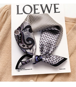 Detail of silk scarf with paisley and lilac geometric pattern on a magazine