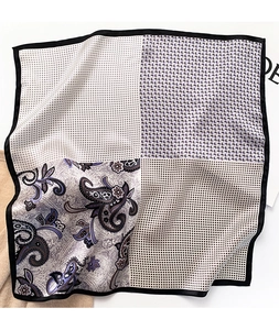 Detail of silk square scarf featuring paisley and geometric patterns with black borders