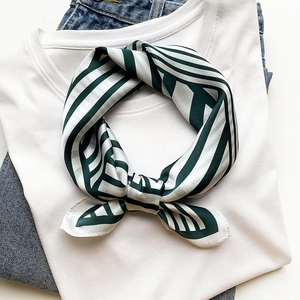 Classic striped silk scarf in dark green and cream white, styled over a white t-shirt