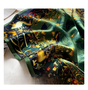 Detailed macro view of the dense machine-stitched edge on a green silk floral scarf