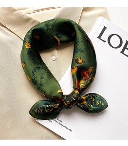 Detail of silk-feel scarf with vintage floral bird print tied on a shirt collar