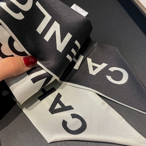 Detail of elegant black and white silk twilly scarf with alphabet print and fine stitching