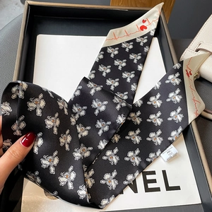 Detail of silk-feel skinny scarf with floral print and heart patterns in a black gift box