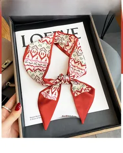 Detail of a geometric pixel pattern silk scarf tied in a bow on a stylish magazine tray
