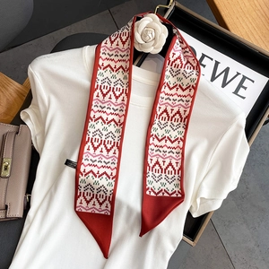 Detail view of retro geometric print twilly silk scarf styled on a white knit sweater