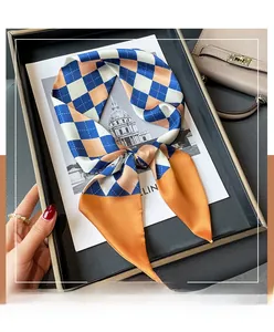 Détail d'un foulard en soie à motif losanges avec contraste bleu marine et orange vif