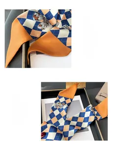 Détail d'un foulard en soie aux motifs géométriques bleu et orange et motif papillon