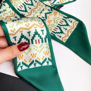 Macro detail of deep green twilly scarf with pixelated geometric patterns and silk texture