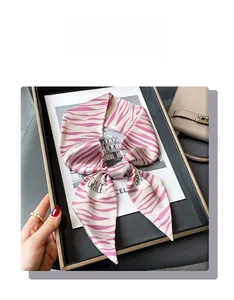 Gros plan d'un foulard en soie à motif zébré rose avec lettrage décoratif élégant