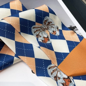 Gros plan d'un foulard en soie à losanges avec nœuds léopard et texture en sergé