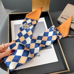 Détail du foulard étroit en soie à motif losanges avec des graphiques de nœuds dessinés