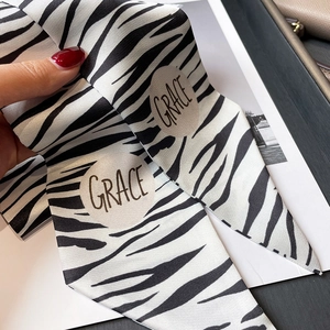 Détail d'un foulard en soie à motif zèbre avec lettrage Grace et texture en sergé