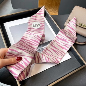 Détail d'un foulard en soie à motif zébré rose avec logo élégant sur tissu de qualité