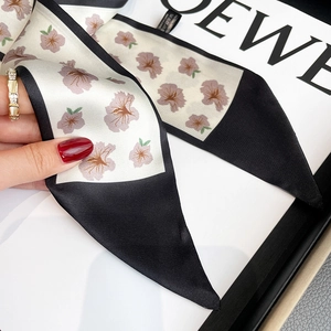 Macro detail of floral silk twilly scarf with elegant black borders and fine texture