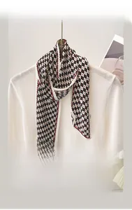 Détail d'un foulard en soie à damier et points rouges noué sur une chemise blanche chic