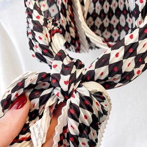 Gros plan d'un foulard plissé avec motif à carreaux noir blanc et cœurs rouges
