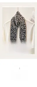 Macro detail of floral pleated silk scarf featuring white flowers on a black background