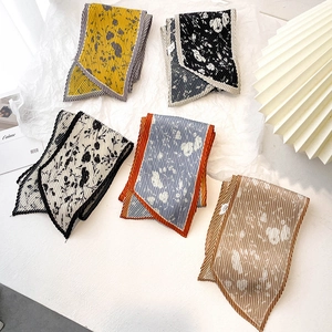 Détails macro des foulards plissés twilly aux motifs floraux et géométriques variés