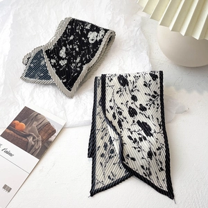 Détail de foulards étroits plissés à fleurs noires et blanches avec texture accordéon