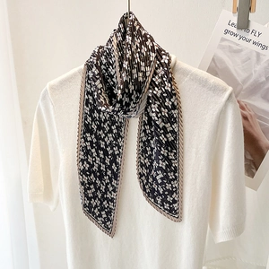 Elegant pleated black floral skinny scarf draped on a white shirt for women