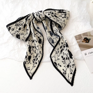 Détails d'un foulard plissé à motif floral avec bords noirs et style vintage élégant