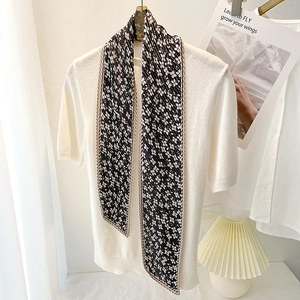 Floral pleated skinny scarf tied on a white knit top for a minimalist spring fashion look