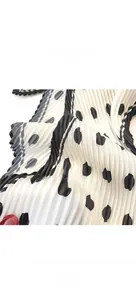 Macro detail of French polka dot pleated silk scarf showing fine edge stitching texture