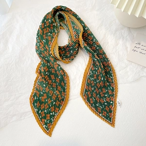 Detail of floral pleated skinny scarf in dark green and orange showing texture