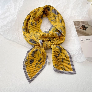 Foulard plissé jaune vif avec motifs floraux élégants sur fond blanc épuré