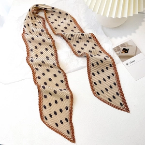 Detailed view of the pleated texture and polka dot pattern on the long skinny silk scarf
